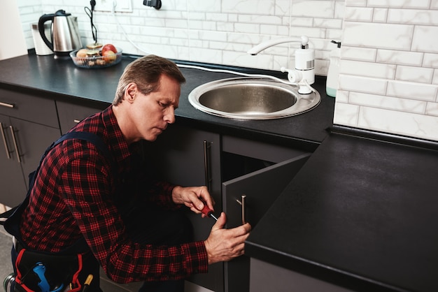 Fixing sink process seniour handyman repairing washbasin