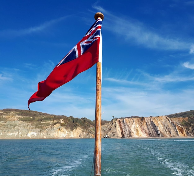 Flag against blue sky over sea