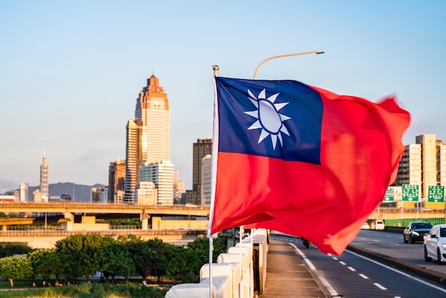 Flag against buildings in city against blue sky