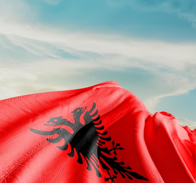 flag of albania waving in beautiful sky.