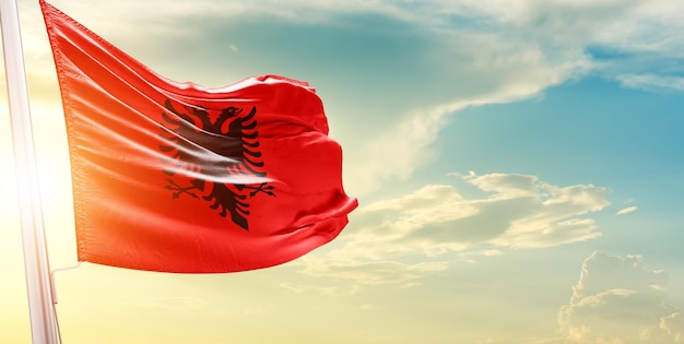 flag of albania waving in beautiful sky.