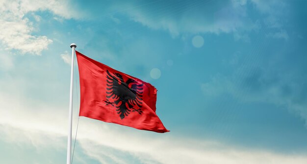 flag of albania waving in beautiful sky.