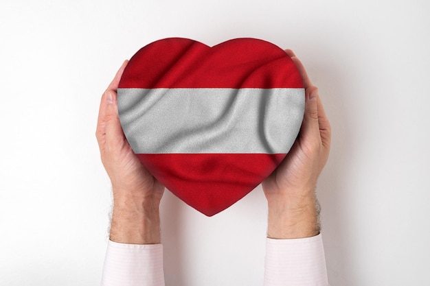 Flag of Austria on a heart shaped box in a male hands White background