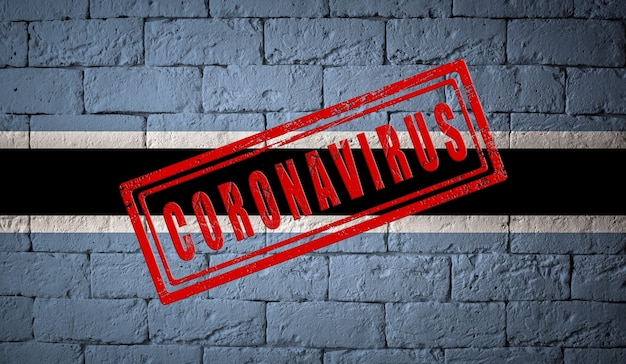 flag of the botswana on brick wall texture stamped of coronavirus corona virus concept