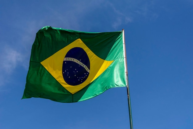 Flag of Brazil fluttering in the blue sky