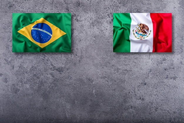 コンクリートの背景にブラジルとメキシコの旗。
