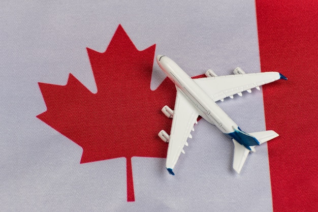 Flag of Canada and model airplane. Flights to Canada after quarantine. Resumption of flights