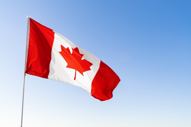 Flag of Canada waving against clear blue sky