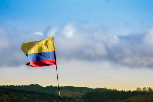 Foto bandiera della colombia in un bellissimo paesaggio con montagne