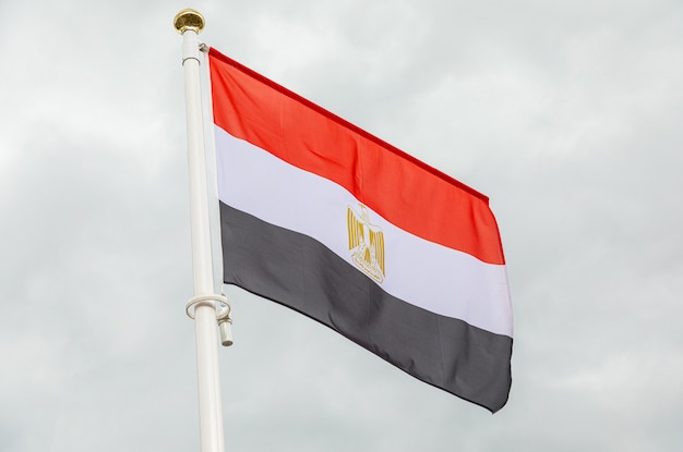 Flag of Egypt against white cloudy sky