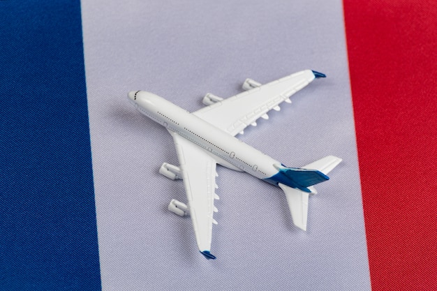 Flag of France and toy plane. Concept of air travel in France. Air travel in Europe after quarantine