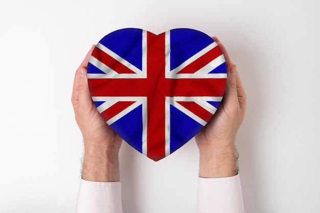 Flag of Great Britain on a heart shaped box in a male hands. 