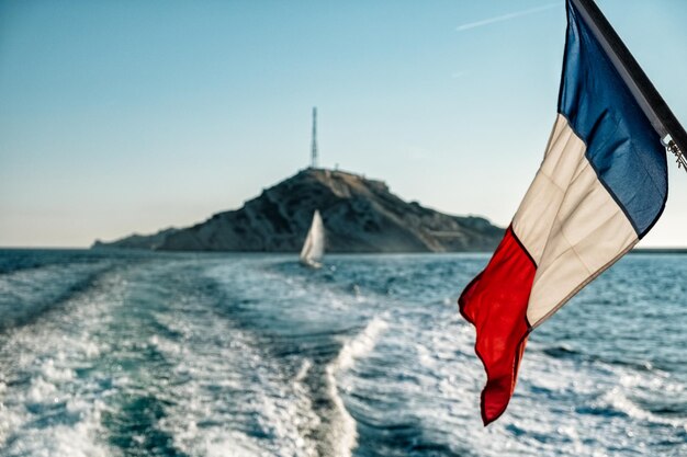 Foto la bandiera che pende sul mare contro il cielo