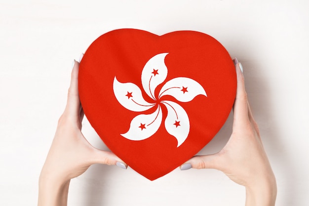 Flag of Hong Kong on a heart shaped box in a female hands