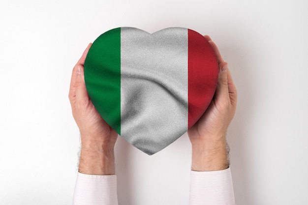 Foto la bandiera dell'italia su un cuore ha modellato la scatola in mani maschii.