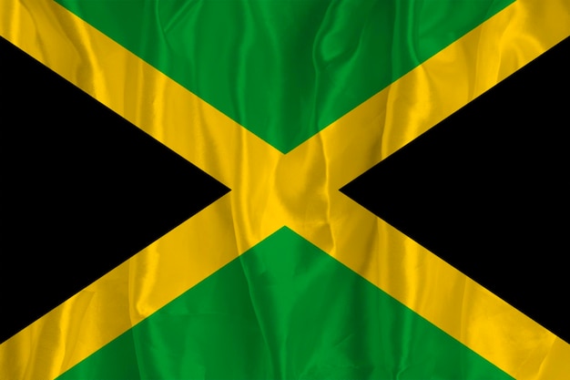 The flag of Jamaica on a silk background is a great national symbol Texture of fabrics The official state symbol of the country