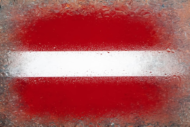 Flag of Latvia Flag of Latvia on background of water drops Flag with raindrops Splashes on glass