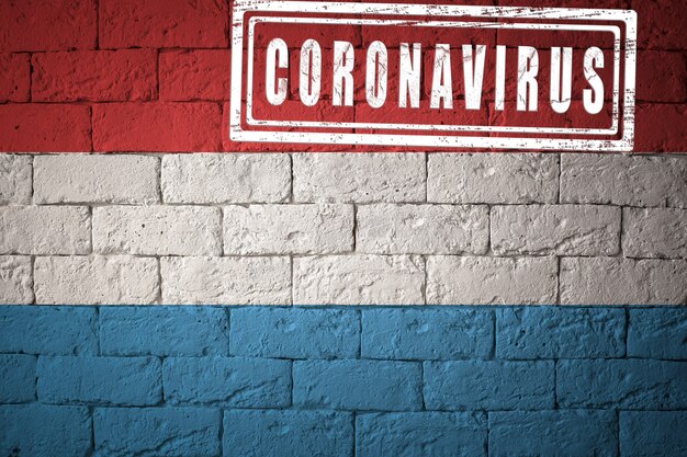 Flag of the luxembourg with original proportions. stamped of coronavirus. brick wall texture. corona virus concept. on the verge of a covid-19 or 2019-ncov pandemic