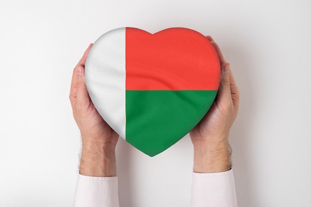 Flag of Madagascar on a heart shaped box in a male hands. White background