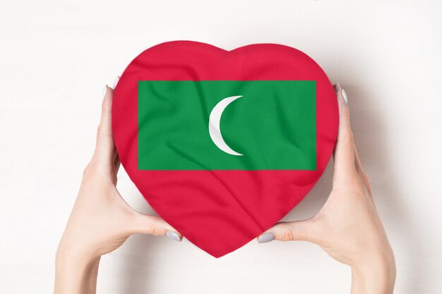 Flag of Maldives on a heart shaped box in a female hands. 