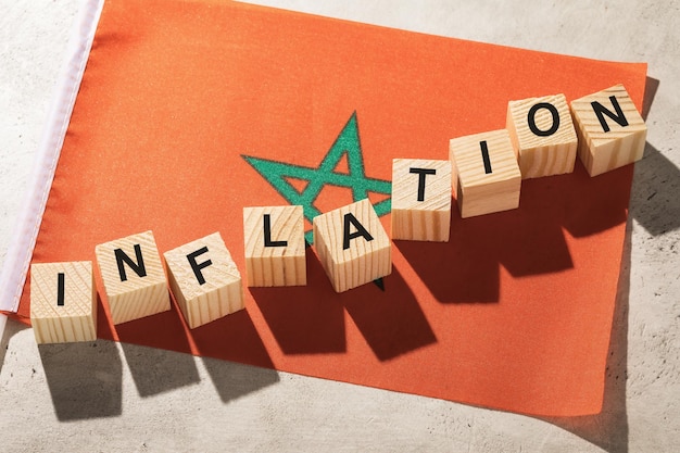 Flag of Morocco and wooden cubes with text concept on the theme of inflation in the country