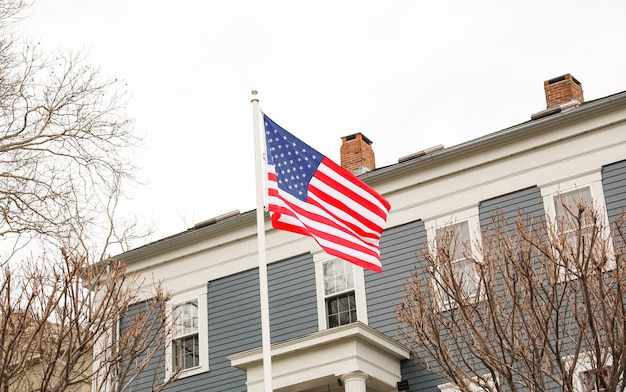 A flag outside a house with a house in the background