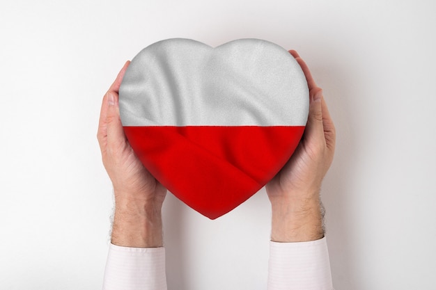 Photo flag of poland on a heart shaped box in a male hands. white background