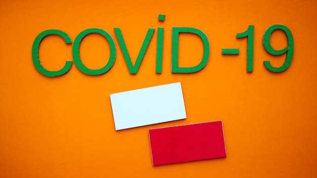 Flag of Poland And Word COVID19 made of green cardboard letters isolated on orange background World Health Organization WHO introduced new official name for Coronavirus disease named COVID19