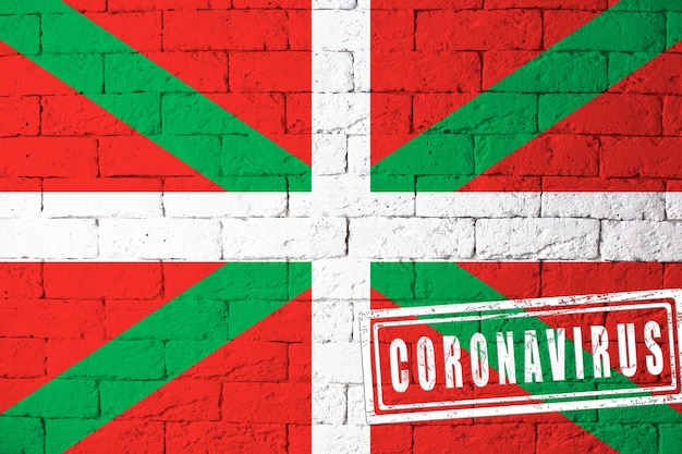 Flag of the regions or communities of Spain Basque Country original proportions. stamped of Coronavirus. brick wall texture. Corona virus concept. On the verge of a COVID-19 or 2019-nCoV Pandemic.