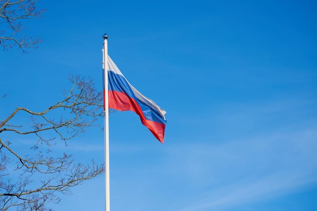 The flag of russia against the blue sky