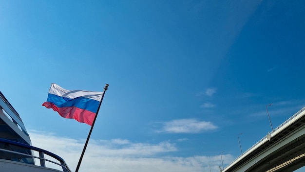 The flag of the Russian Federation against the background of a blue sky