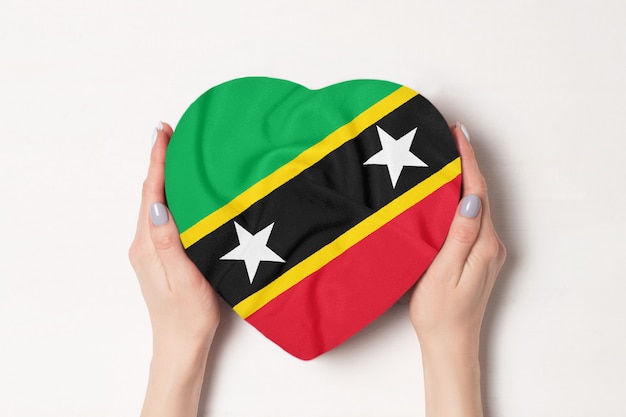 Flag of Saint Kitts and Nevis on a heart shaped box in a female hands.