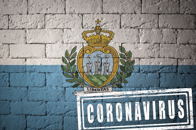 Flag of the San-Marino with original proportions. stamped of Coronavirus. brick wall texture. Corona virus concept. On the verge of a COVID-19 or 2019-nCoV Pandemic.