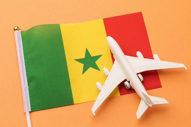 Flag of Senegal and a toy plane on an orange background