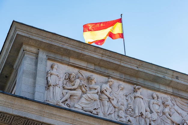 Flag of Spain atop the facade of the Prado Museum in the city of Madrid Spain