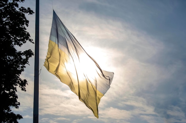 Flag of the state of Ukraine against the background of the bright sun