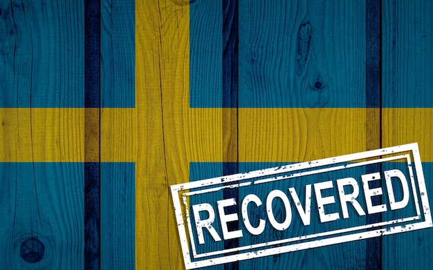 Flag of Sweden that survived or recovered from the infections of corona virus epidemic or coronavirus. Grunge flag with stamp Recovered