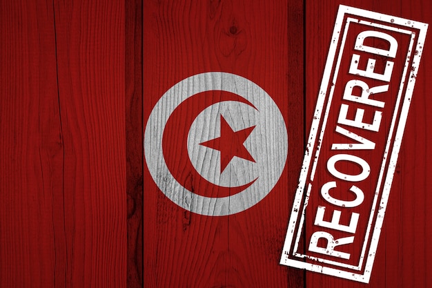 Flag of Tunisia that survived or recovered from the infections of corona virus epidemic or coronavirus. Grunge flag with stamp Recovered