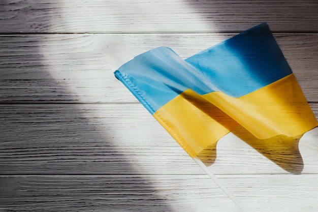 The flag of Ukraine is blue and yellow on the background of wooden figured boards