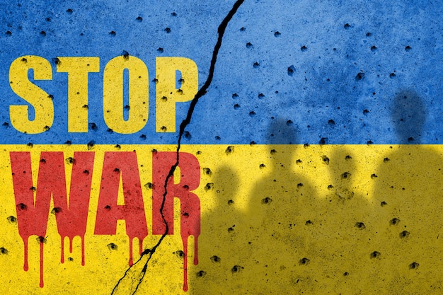 Flag of Ukraine painted on a concrete wall with word STOP WAR Russian military aggression