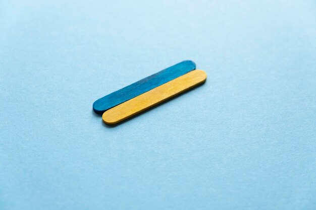 Photo flag of ukraine side view. wooden sticks on a blue background. blue and yellow color