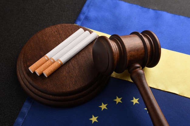Bandiera dell'ucraina con bandiera dell'unione europea sigarette e martelletto del giudice trasporto illegale di prodotti del tabacco contrabbando tra l'ucraina e l'ue