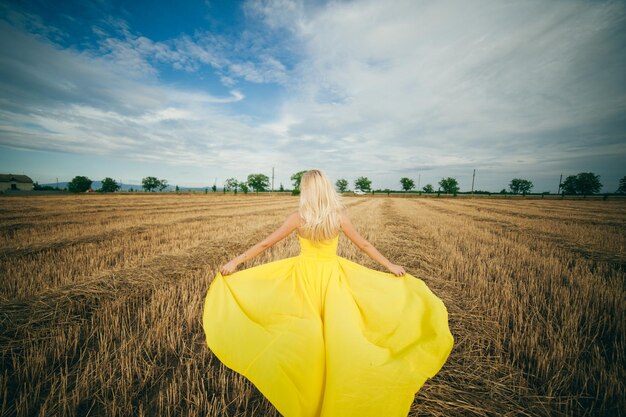 Flag of ukraine yellow field and blue sky a girl with white\
hair holds a yellow dress i