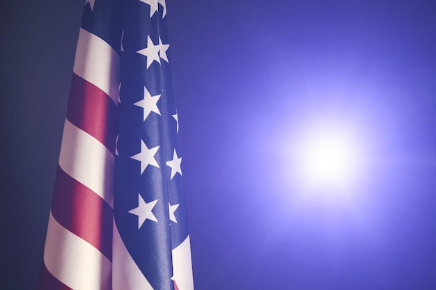 Flag of the United States of America against background bright light from camera flash.