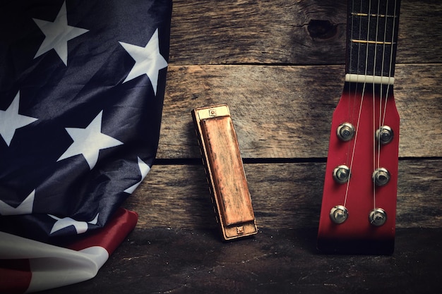 Foto bandiera degli stati uniti d'america armonica e collo di chitarra su un vecchio sfondo di legno