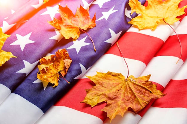 Flag United States of America is strewn with yellowed autumn maple leaves