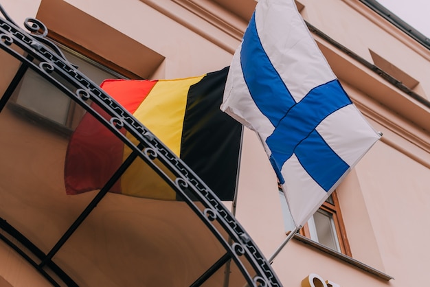 Foto asta della bandiera sull'edificio con la bandiera finlandese e belga