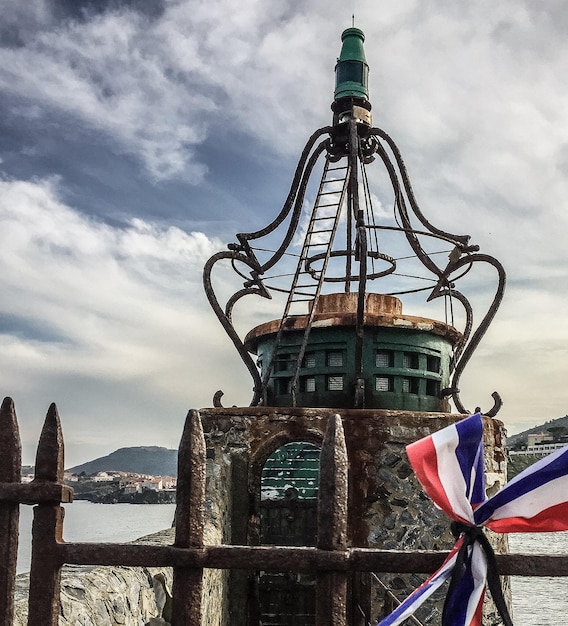 Photo flags against lighthouse by sea