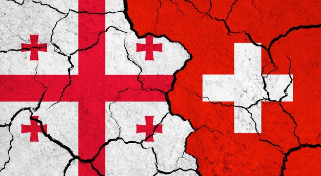 Flags of georgia and switzerland on cracked surface politics relationship concept