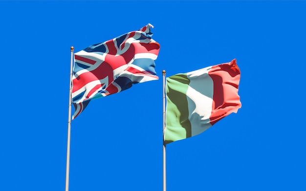 Flags of Italy and UK British on blue sky. 3D artwork